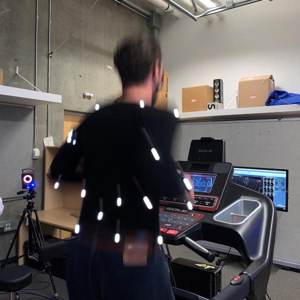 A man in blurred motion is running on a stationary treadmill while tracking his motion.